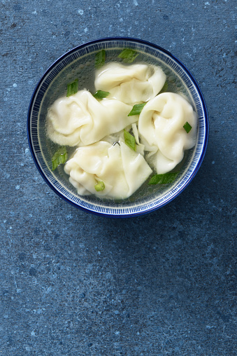 Bowl of wonton soup with chives