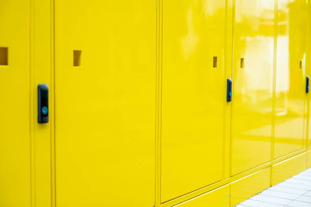 istock Yellow wall and Electrical control panel beside the yellow locked locker for students at university that have number on locker and keys for each students. Decoration and design. close up 1227320652