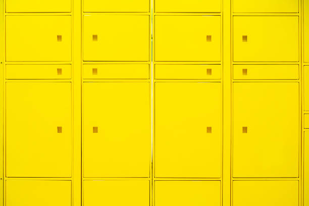 istock Yellow wall and Electrical control panel beside the yellow locked locker for students at university that have number on locker and keys for each students. Decoration and design. close up 1227320670