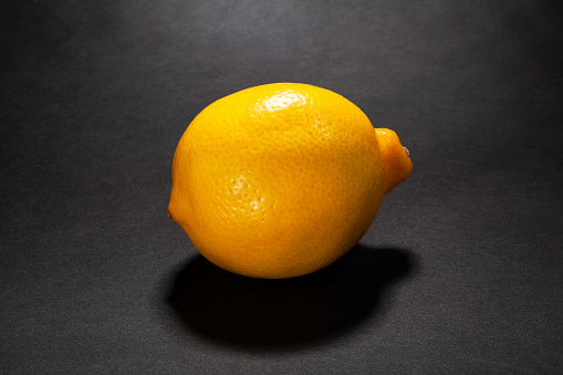 whole lemon on black background