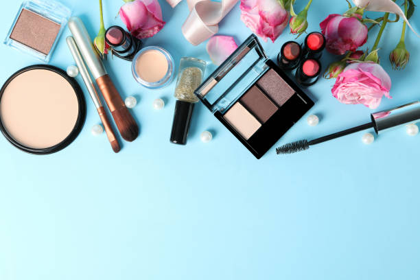 istock Different makeup cosmetics and flowers on blue background. Female accessories 1227321611