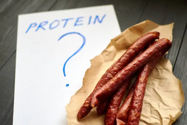 Protein and question mark and different sausages and sausages. Unhealthy eating concept.