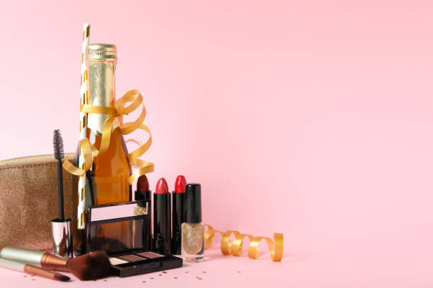 istock Different makeup cosmetics and champagne on pink background. Female accessories 1227321922
