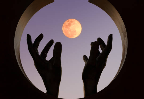 istock Hands covering moon at sunset 1227322211