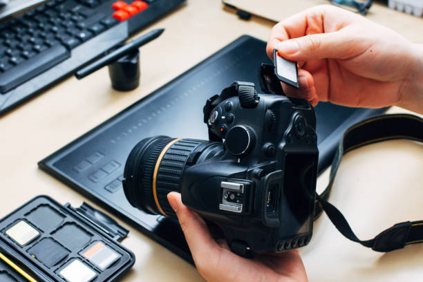 istock unrecognizable person holding a camera and insert a memory card into it 1227322396