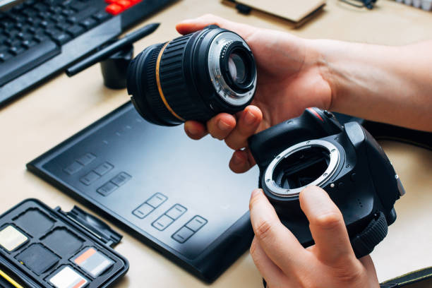 istock unrecognizable person holding a camera and puts the lens 1227322411