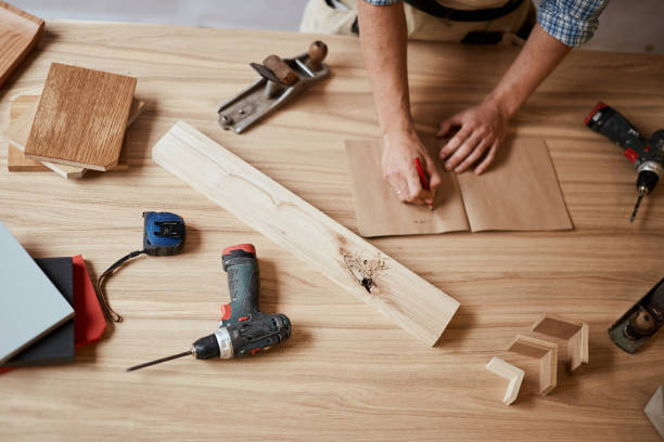 istock Closeup view of a carpenter using a red pencil to draw a line on a blueprint 1227325252