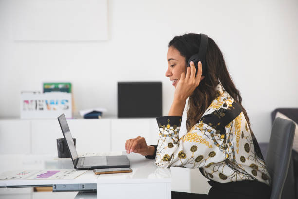 Woman working from home and relaxing having a video conference with business partners during Coronavirus pandemic.