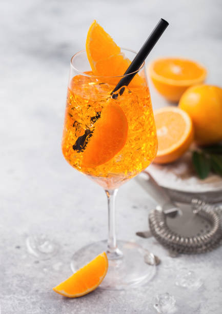istock Spritz summer cocktail in wine glass with oranges and strainer on light background. 1227327279