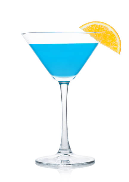 istock Blue lagoon summer cocktail in martini glass with orange slice on white. 1227328749