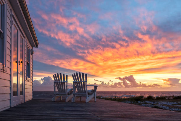 deux chaises d’ampty faisant face à la vue magnifique de coucher de soleil à la plage - villa photos et images de collection