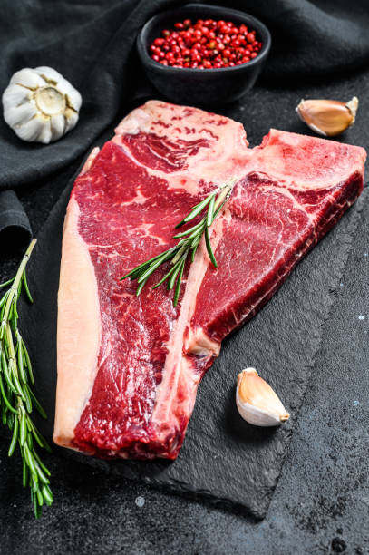 istock T bone steak. Organic raw Tbon beef. Black background. Top view 1227331692