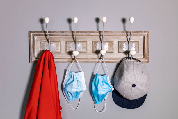 Coat rack with a jacket, a cap and a pair of safety mask. Coat rack with a jacket, a cap and a pair of safety mask. coat hook photos stock pictures, royalty-free photos & images