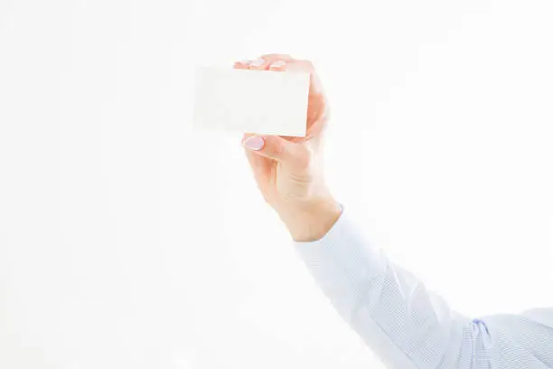 Photo of female hand holding business card isolated on white background. Copy space