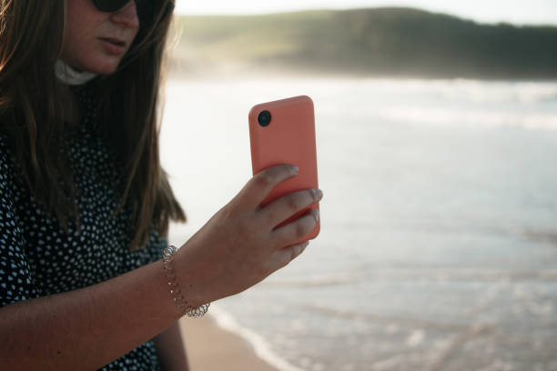 istock Young woman at beach using phone 1227335561