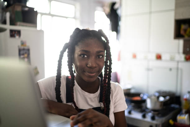 portrait of teenager using her laptop at home - crimped imagens e fotografias de stock