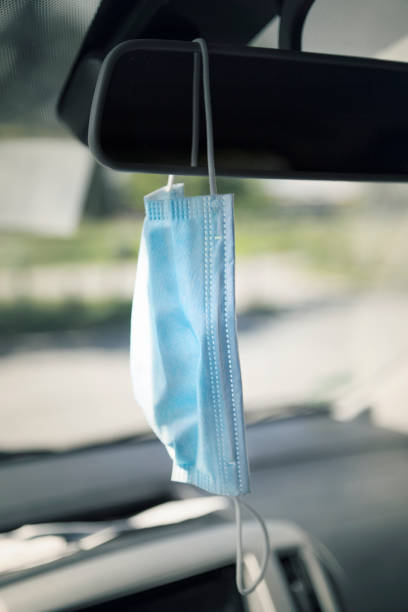 istock Face mask hanging on the rear-view mirror 1227336436