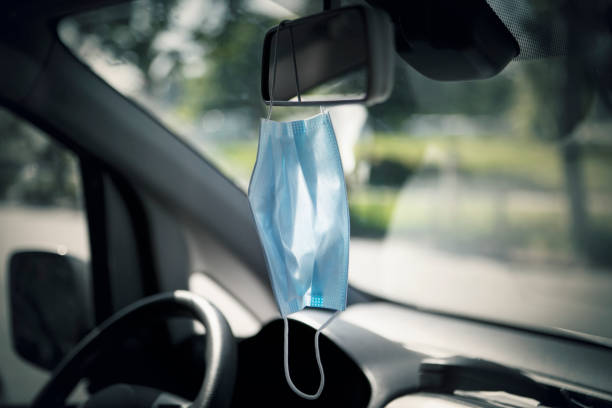 istock Face mask hanging on the rear-view mirror 1227336464