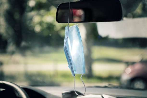 istock Face mask hanging on the rear-view mirror 1227336509