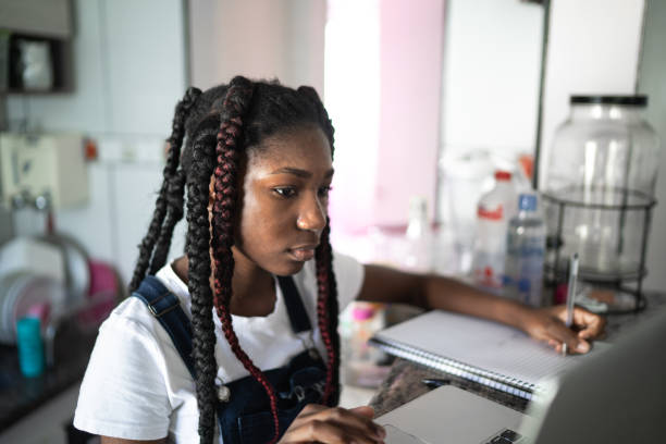 istock Concentrated teenager using laptop at home 1227338821