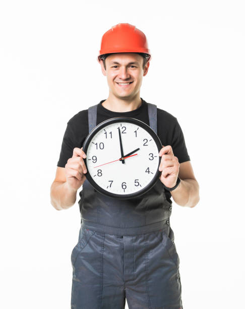 istock Young handyman worried about the time on white background 1227341033