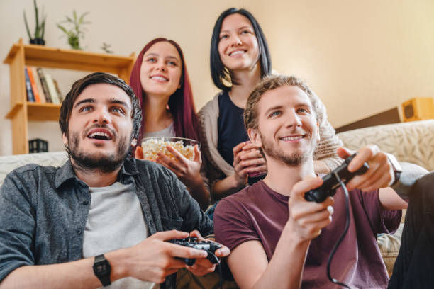istock Multiethnic joyful group of young people playing games on console while having party at home 1227346868