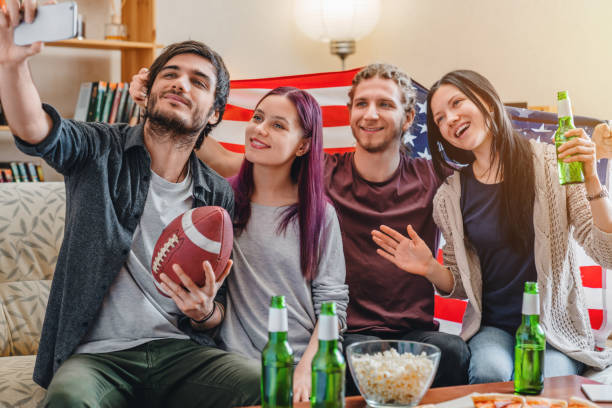 young friends making selfie while watching american football on tv - american football football food snack imagens e fotografias de stock