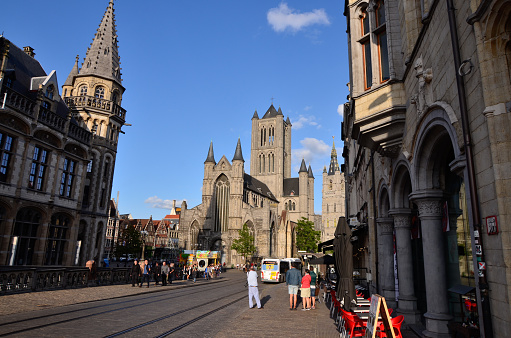 Ghent, Belgium, August 2019. In the historic center, one of the most beautiful views of the city: the bridge of St Michael.  in the direction of the church of San Nicola. People stop to enjoy the view.
