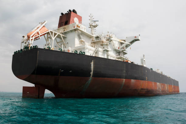 un petrolero anclado cerca de una terminal de petróleo y una plataforma offshore en el golfo pérsico - buque tanque petrolero fotografías e imágenes de stock