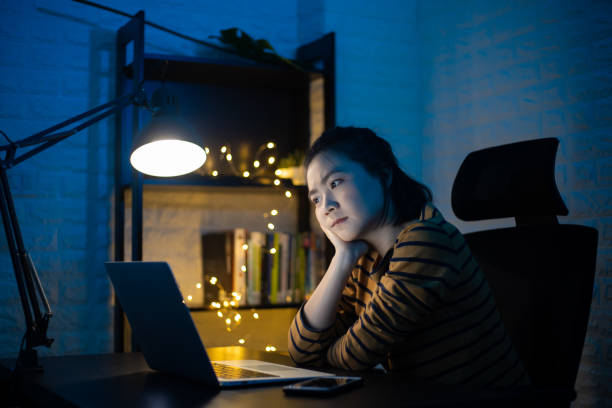 istock Asian woman seriously working on a laptop overtime at home. WFH. Work from home for avoid the Coronavirus COVID 19 concept. 1227348213