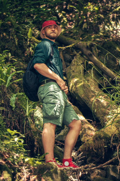 istock Hiker with backpack walking in mountain forest, climbing to the cliff 1227348340