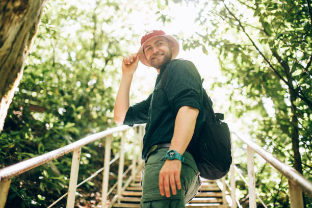 istock traveler with backpack climbing over wooden bridge in green forest 1227348428