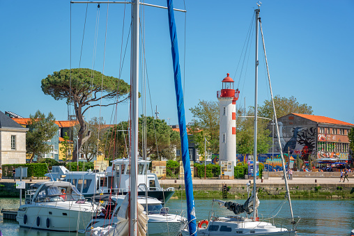 Red lighthouse and sailboats in the old harbor of La rochelle, France