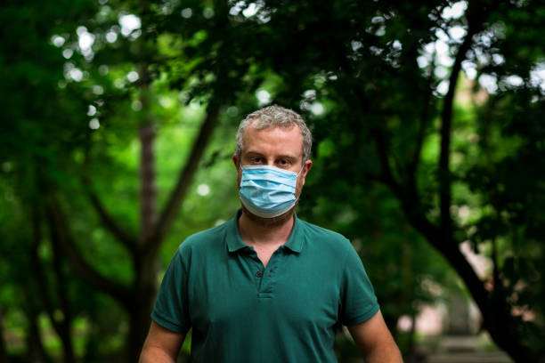 istock Man exercising at outdoor gym wearing protective face mask 1227351909