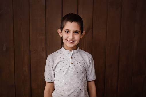 Happy boy in polo shirt. Isolated over brown background. Schoolboy. Teenager.