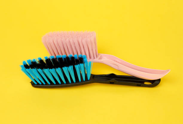 istock black anf pink plastic brushes for cleaning the house on a yellow background 1227354979