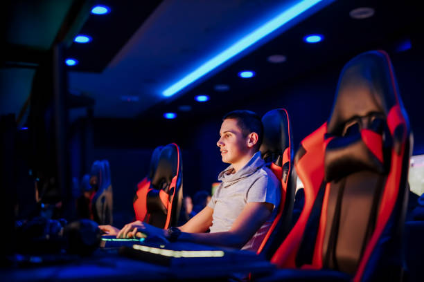 istock Young gamer playing video game in modern playroom with blue neon light. 1227355387