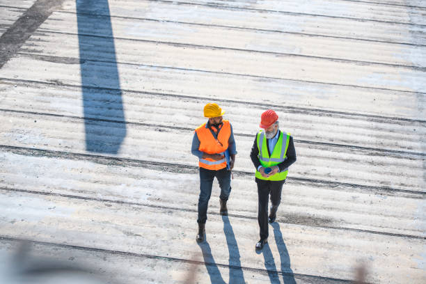 istock High Angle View of Construction Coworkers Talking Onsite 1227356677