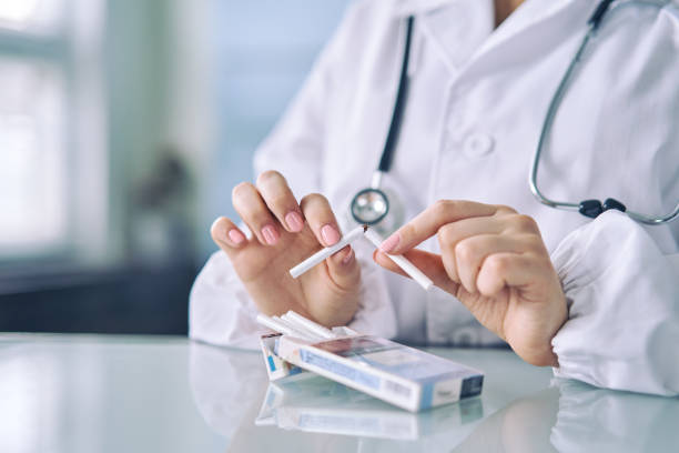 mani del medico che tengono una sigaretta rotta, concetto di stile di vita sano - tobacco sticks foto e immagini stock