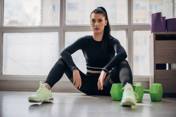 istock Fit lady sitting on the floor alone in gym 1227359654