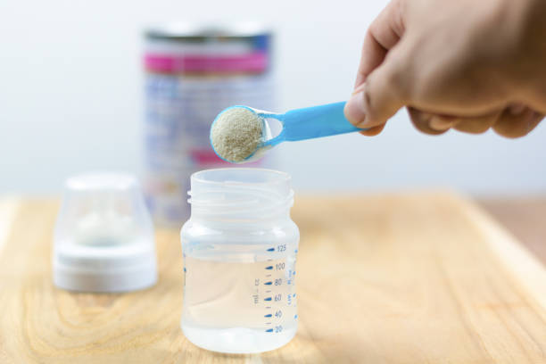 latte in polvere per neonati con cucchiaio di misurazione latte in polvere con un cucchiaio per neonati latte e flacone per neonati - spoon plastic isolated white foto e immagini stock