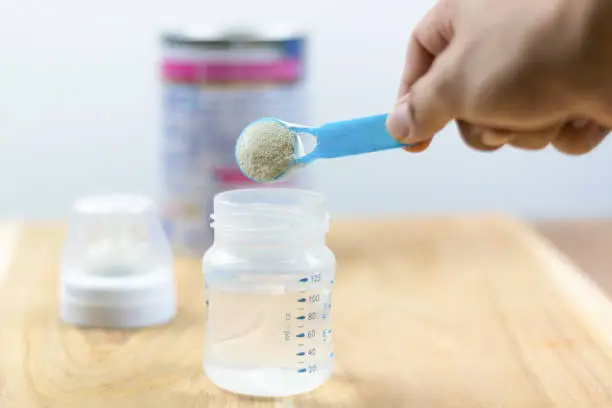 Infant formula milk using a measuring spoon Powdered milk with a spoon for babies Infant formula and bottle