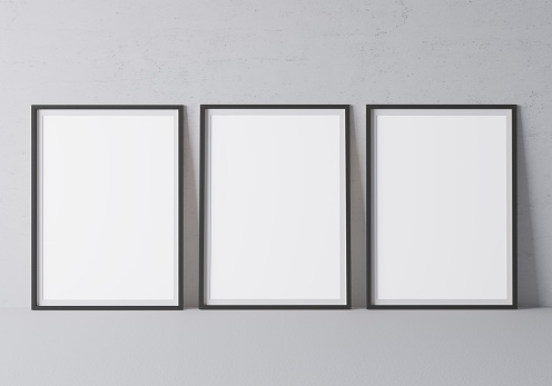 Three black vertical frames mock up. Frame poster size A4, A3 standing on gray floor. Stock photo