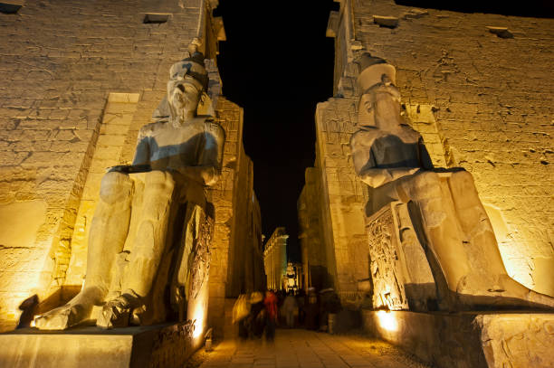 istock Statue and hieroglyphic carvings at an ancient egyptian temple in night 1227361224