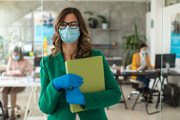 istock Female bank manager with protective face mask in office 1227361972