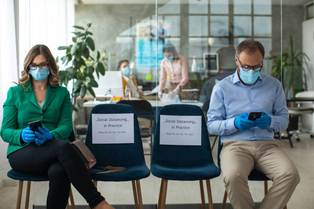 istock Two clients keeps social distancing at bank waiting room 1227362360