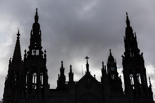 silhouette of a cathedral with large turrets, backlight on a stormy day