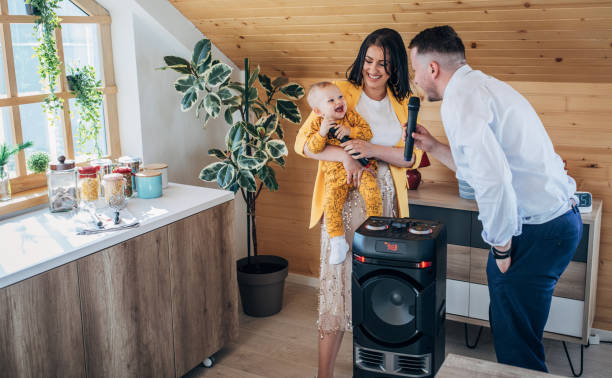 familia feliz con su hijo, cantando y bailando en casa - babies and children audio fotografías e imágenes de stock