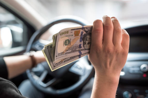 Man With Money in Car Close-up of man with money in car. cash for cars stock pictures, royalty-free photos & images