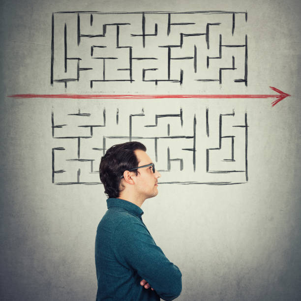 istock Businessman wears eyeglasses, looking determined as found the perfect solution to solve the labyrinth game. Student breaks the rules, as red line pierce the maze walls. Different thinking concept. 1227365538